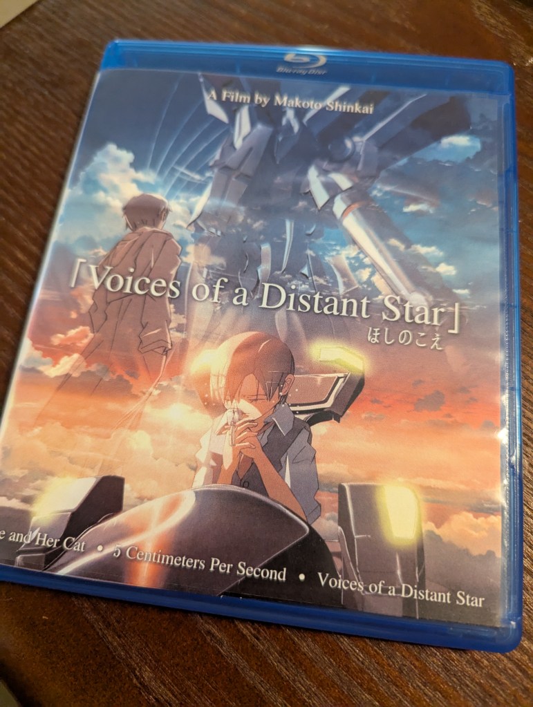 a blue-ray disc with a cover reading "Voices of a Distant Star" with that film's cover art, and "5 Centimeters Per Second" listed in small print at the bottom